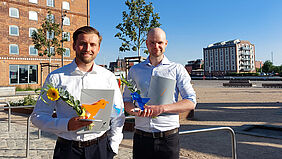 Die Preisträger sind vor dem InnovationPort Wismar nebeneinanderstehend und lächelnd zu sehen.