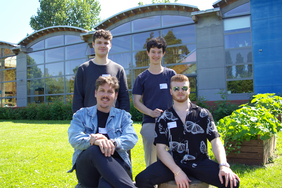 Four male students pose outside in front of the StartUpYard building after receiving second place in the student category at the INSPIRED competition.