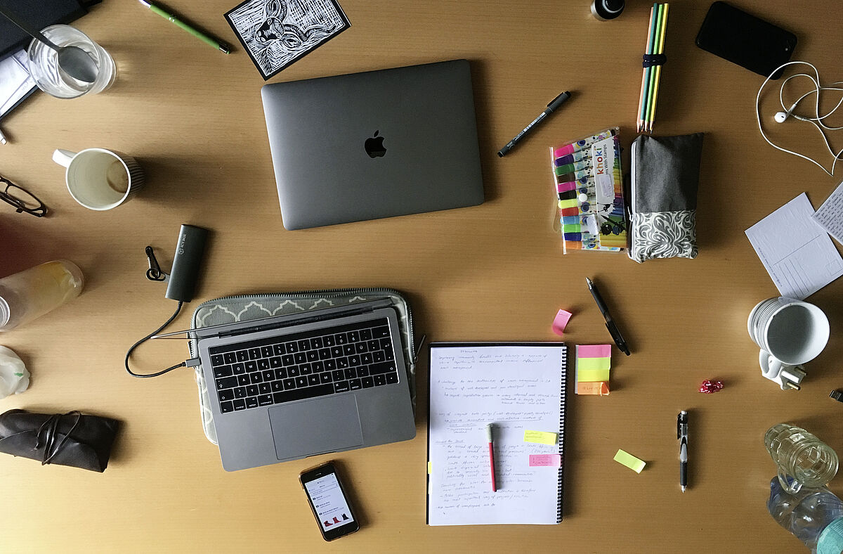 work table  with laptops, writing pady and highlighters 
